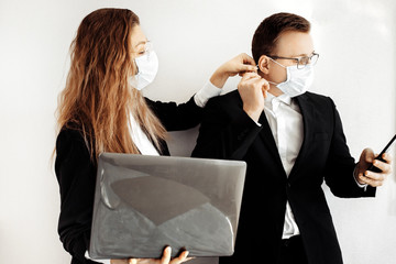 Office workers with laptop and phone work at office using medical face mask. Coronavirus pandemic .