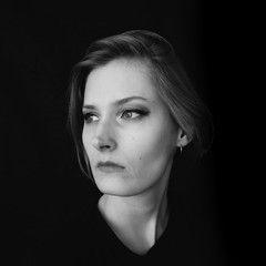 Fototapeta premium Black and white portrait of a girl on a black background. Powerful energy concept.