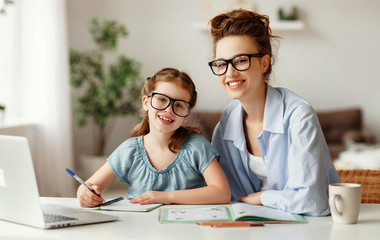 Fototapeta na wymiar Happy girl with mother studying online at home