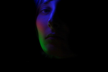 Dark portrait of a girl in color lighting