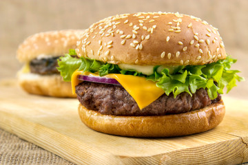Homemade hamburgers on wooden board closeup