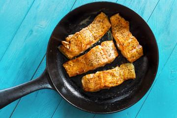 Pan seared salmon fillets on cast iron skillet , top view