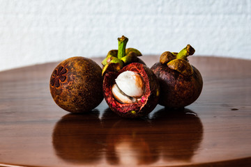 Mangosteen on wooden table against white background.