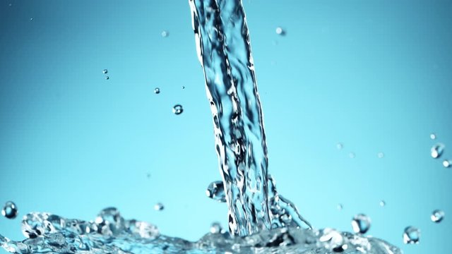 Super slow motion of pouring splashing water on blue background. Filmed on high speed cinema camera, 1000fps.