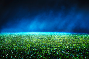Night low view of maintained lawn at football stadium.
