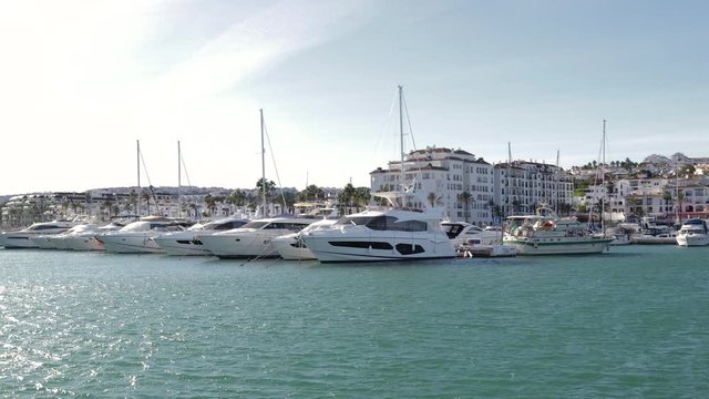 MANILVA, MALAGA / Spain - December 14 2019: Beautiful panoramic view of "Puerto de la Duquesa" Yachts and boats docked in the Harbour. Luxury Apartment Urbanisation and Restaurants. No camera movement
