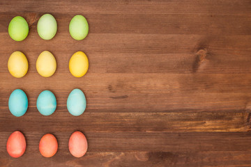 easter eggs collection as a background. Multi-colored eggs in a row.
Easter eggs on a brown wooden table.