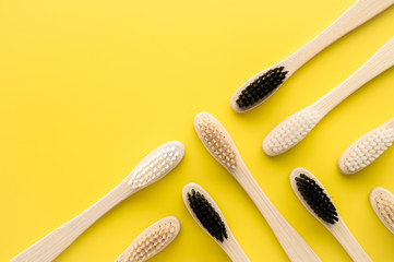 Zero waste concept. Group of eco natural bamboo toothbrushes on a bright yellow background. Flatlay, copy space, horizontal orientation. Layout natural organic hygiene products. no plastic