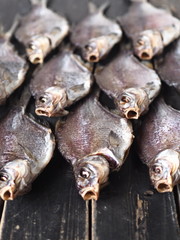 Fish background.A lot of air-dried, salty freshwater bream on a dark wooden table.River fish.