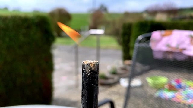 Close up of the orange flame of a burning gas lighter in the garden as a symbol for heat or hotness
