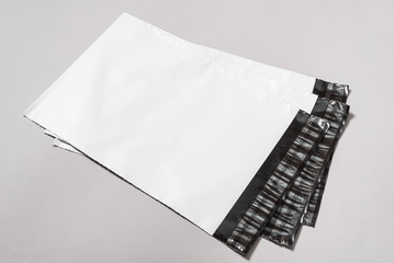 Set of white polythene envelopes on grey background