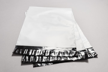 Set of white polythene envelopes on grey background