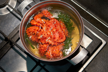 Kamchatka red king crab is boiled in boiling water in a pan.