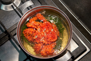 Kamchatka red king crab is boiled in boiling water in a pan.