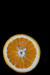 Half orange close-up on a black background for advertising, juicy orange cutaway suitable for menu...