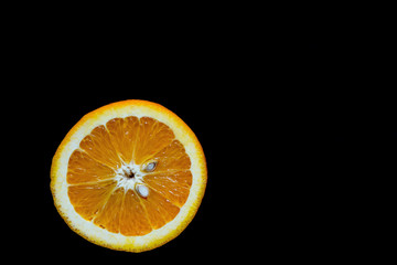 Half orange close-up on a black background for advertising, juicy orange cutaway suitable for menu...