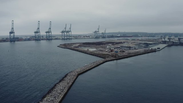 Amazing view of Aarhus harbour on a cold winter day with cranes in the background and small industrial island from aerial drone view