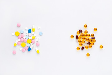 Alternative medicine vs chemical medicine concept. Assorted pills and capsules at white background.