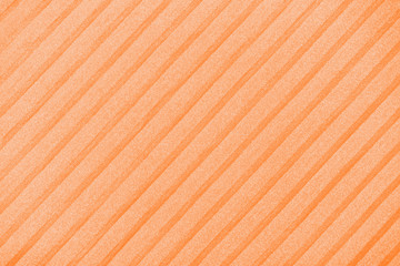 Plisse background toned in trendy color 2020 orange peel. geometric cloth lines. Fabric, textile close up.