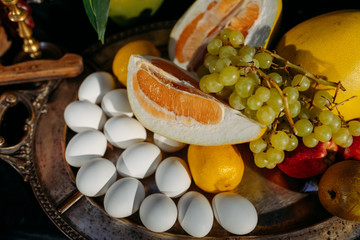 Still life. Steel tray with easter eggs and fruits on a black background. Easter. close-up