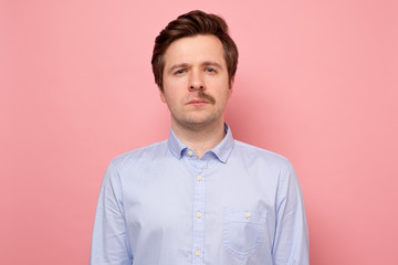 Portrait of a man with a half mustache after shaving on pink wall