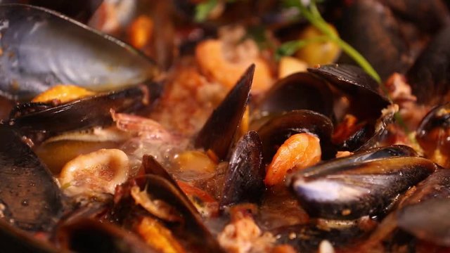 Cooked on the stove traditional Italian Mediterranean fish soup, chowder,with shrimp, mussels tomato, squid, clams.Seafood.Close up