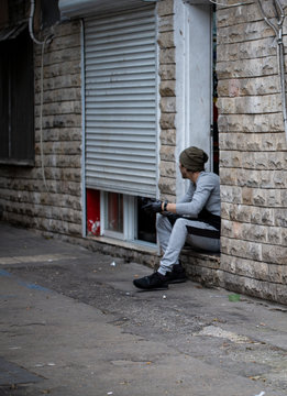 young man leaning against a strit 