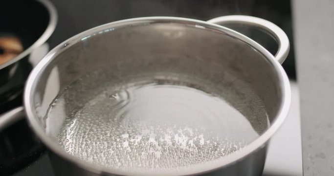 Slow motion handheld hot water in pot before boiling