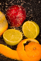 Fototapeta na wymiar orange, lime, niktorin, drops of water on a black background