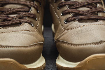 light brown leather sneakers on black concrete