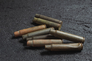 old rusty spent shells on black concrete
