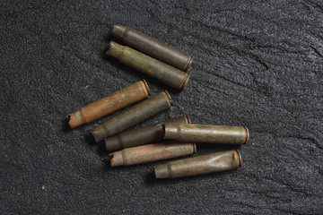 old rusty spent shells on black concrete