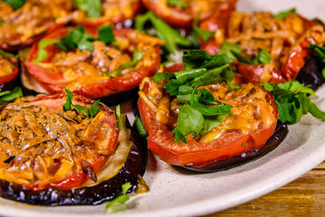 Baked eggplants with tomatoes and cheese in a ceramic plate