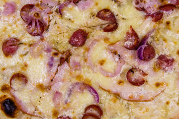 Background of the pizza with sausages, ham and parmesan cheese