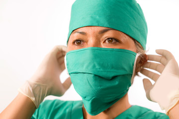 Fototapeta na wymiar closeup portrait of mature attractive and happy medicine doctor woman or hospital nurse in medical scrubs latex gloves and mask confident