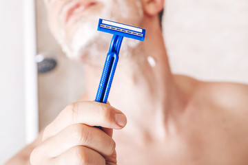 young man shaving. Razor. Bathroom. Beauty photo. Idea. male