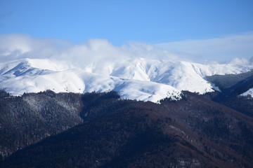 Clouds in snowy mountain tops in winter in Busteni Romania