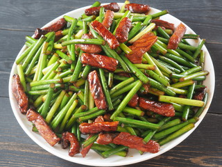 Green sprouts of garlic fried with meat. A popular Chinese dish.