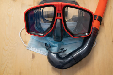 Goggles and snorkel together with mask on a wooden base. Summer concept.
