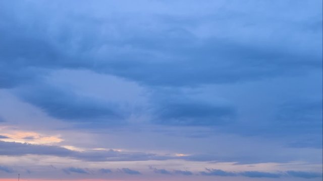 Aerial time lapse of blue veil of clouds moving over horizon in twilight zone. Sunset from the top of the hill in 4k