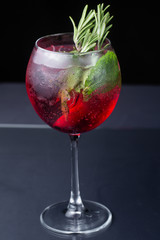 .red refreshing alcoholic cocktail made from cherry juice decorated with mint and cinnamon