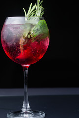 .red refreshing alcoholic cocktail made from cherry juice decorated with mint and cinnamon