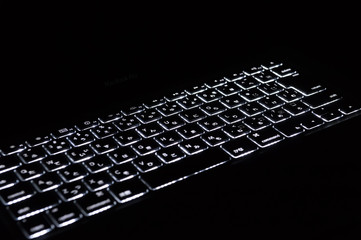 暗闇に光るパソコンのキーボード