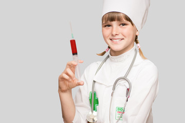 Smiling kid girl playing doctor with syringe isolated on white