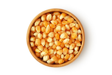 Dried corn kernels in wooden bowl on white background