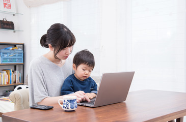 2歳の男の子とパソコンをする母