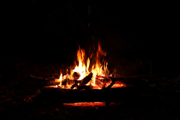 Bonfire by the river in the forest at night. Romantic evening.