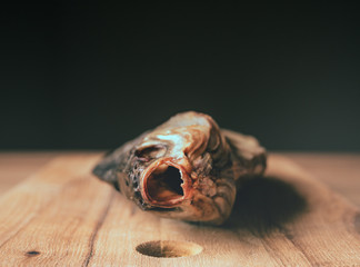 Dried smoked fish smelt, on a wooden board.