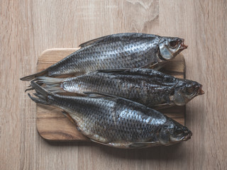 Dried fish on the table. Salty dry river fish on a dark wooden background.