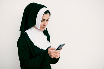 nun with smart phone on white background